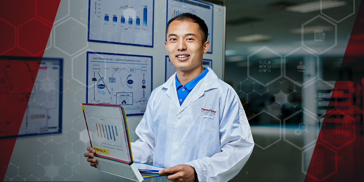 Image of Horry standing in front of a wall of charts and graphs - Horry's work is a story of continuous improvement. Content links to his story.