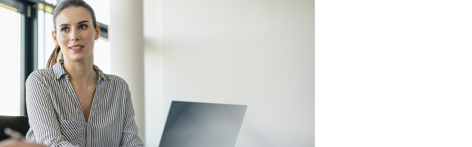 Femal programmer sitting at the desk with a laptop