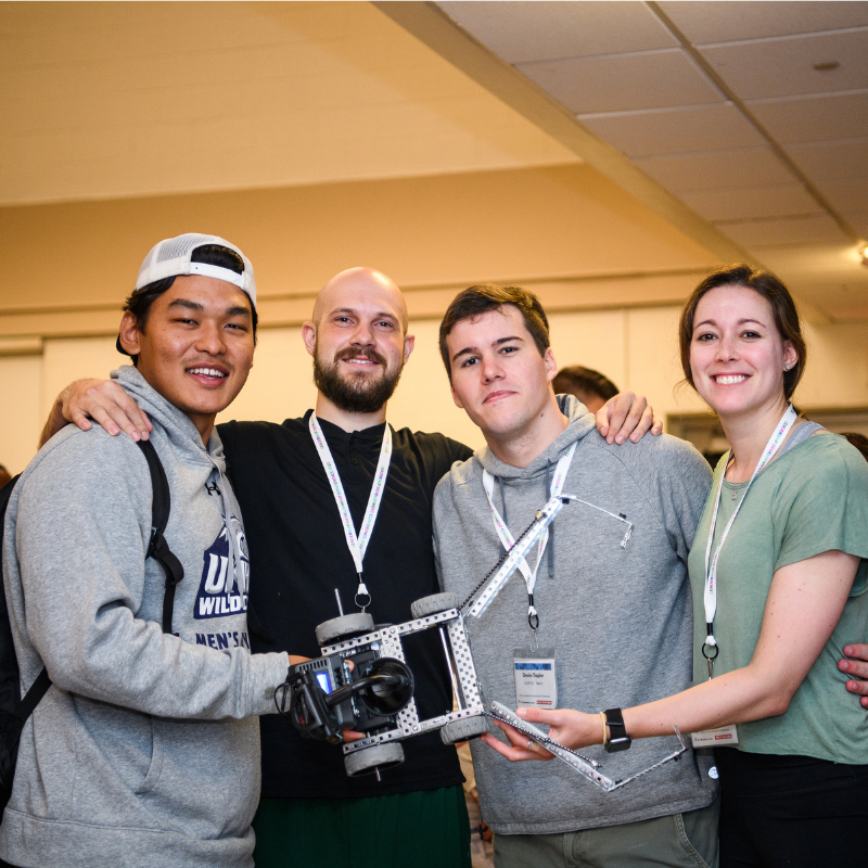 Ashim (Finance LDP, left), Corey (Engineering LDP, center left), Devin (Engineering LDP, center right), and Emily (Engineering LDP, right) pose with their rover they built. 