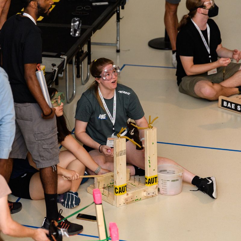 An LDP member watching the developmental lab competition as she builds her own catapult for her team. 