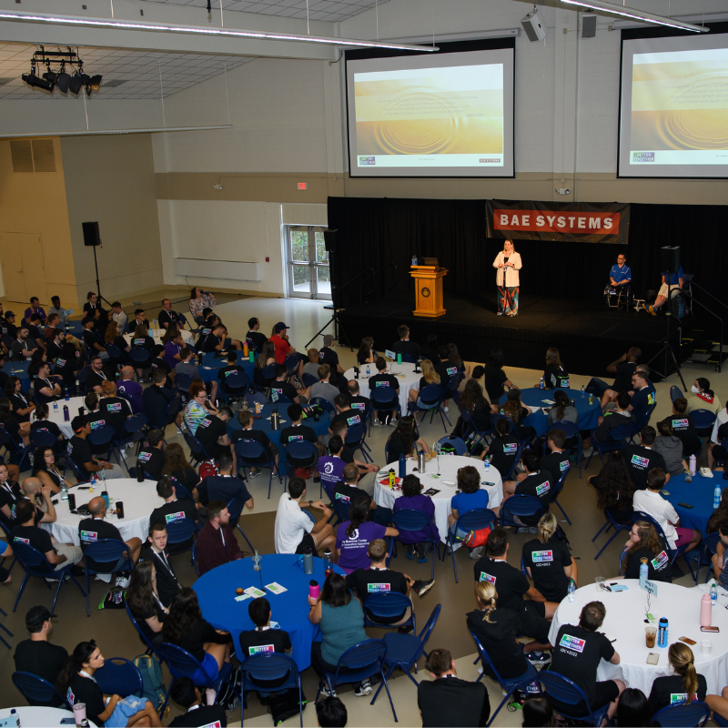 An aerial view of BAE Systems Chief Diversity Officer, Dana Rixter, and representatives from Northeast Passage, a non-profit organization empowering individuals with disabilities presenting on stage to LDP participants on the importance of inclusivity at the 2022 Leadership Development Conference.