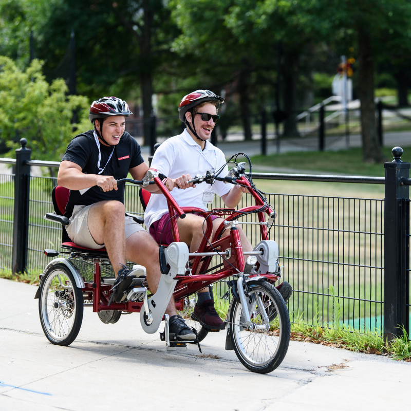 Chris and Kendall, two Finance LDP members, riding a tandem bicycle during a team building activity. 