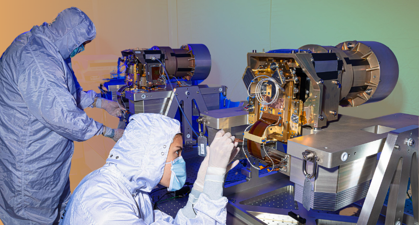 Two BAE Systems Space and Mission Systems sector employee examining space equipment. 