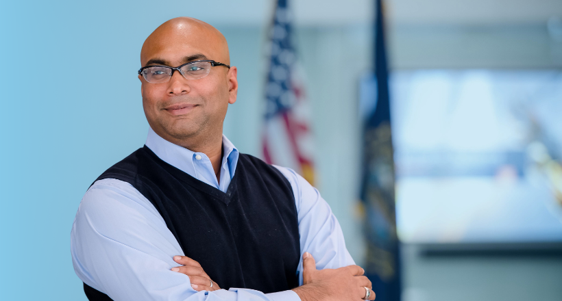 Sayed, an experienced engineer and boomerang employee, poses for a photo in front of the American flag.