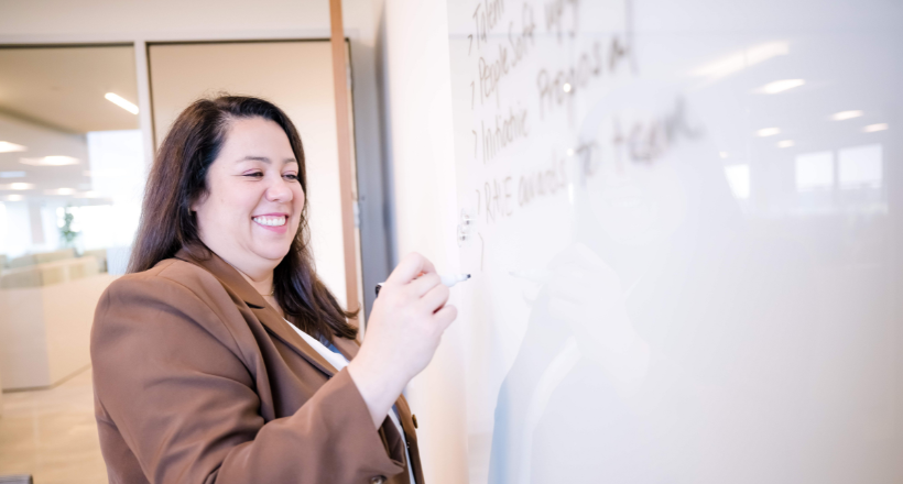 Amy, director of talent management, writing on a white board.