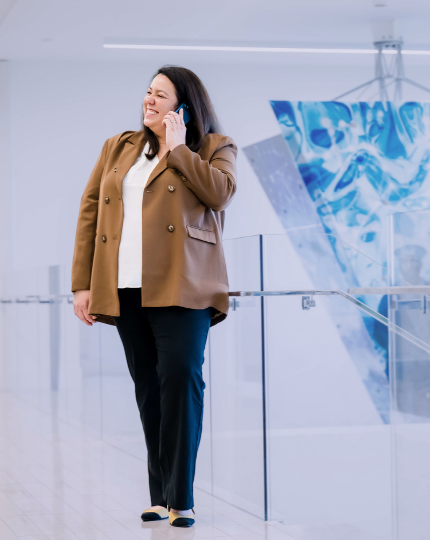 Amy, director of talent management, speaks on the phone while standing in the lobby of Inc. headquarters.
