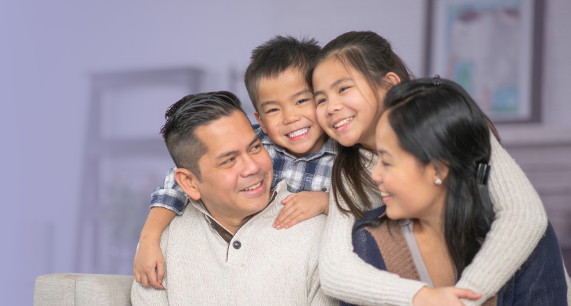 A family hugging in the living room.