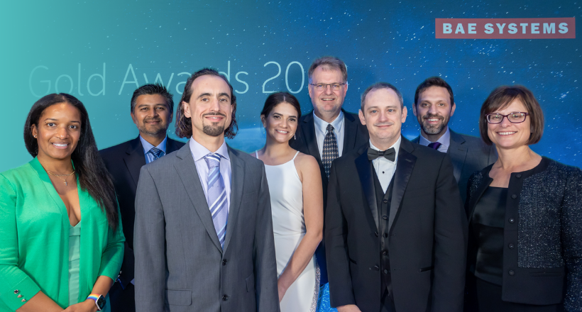 Eight talented BAE Systems employees pose for a photo together at the 2023 Chairman's Gold Awards.