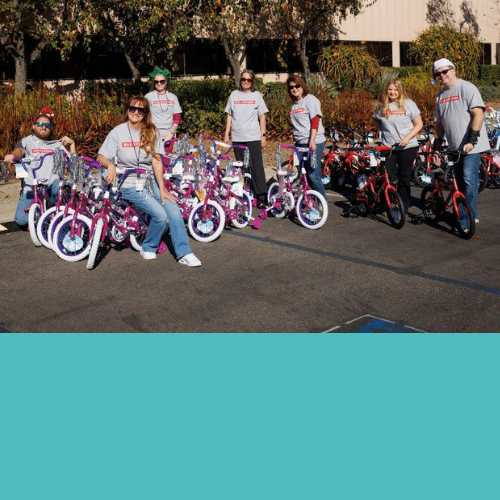 A group of BAE Systems employees getting ready to pack youth bicycles into a truck for donations.