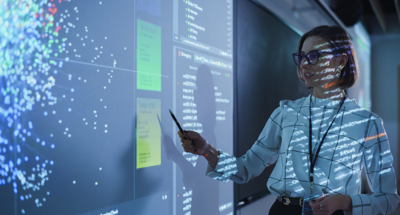 A college professor lectuing in a classroom about futuristic technology. 