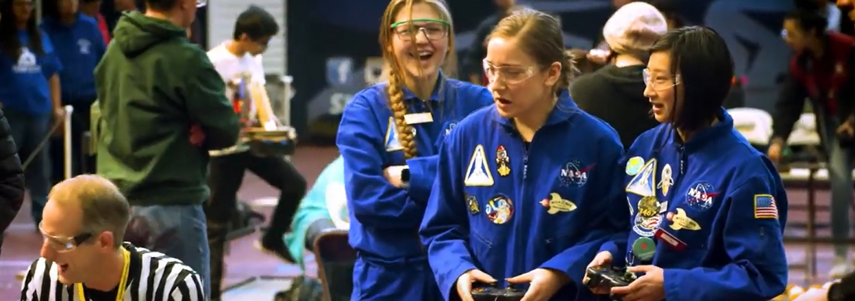 Three young women compete at the FIRST Robotics competition.