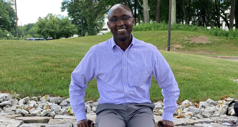 Hosea, a boomerang employee and electrical engineer, smiles for a headshot. 