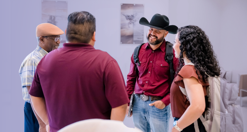 Mike, a software engineer, (wearing the cowboy hat), speaks with colleagues.
