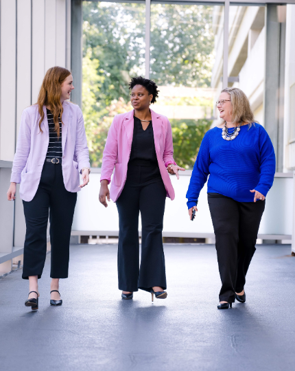 Emily, Tyece, and Rachel, three BAE Systems employees, walk and talk outside of Inc. headquarters.