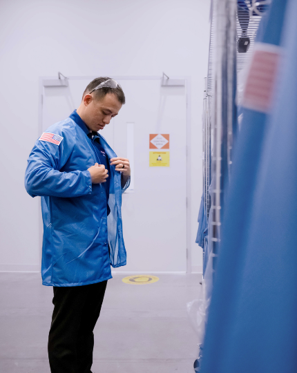 Ryan, a procurement manager, puts on a BAE Systems blue smock as part of his PPE before entering a restricted area.