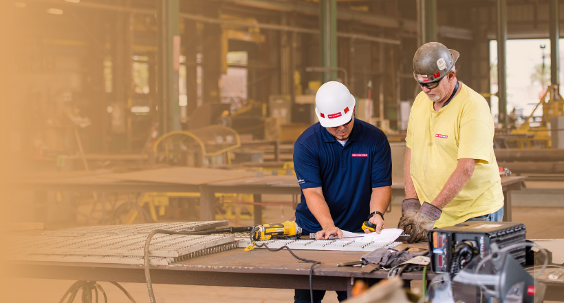 Two employees from platforms and services work in the ship yard.