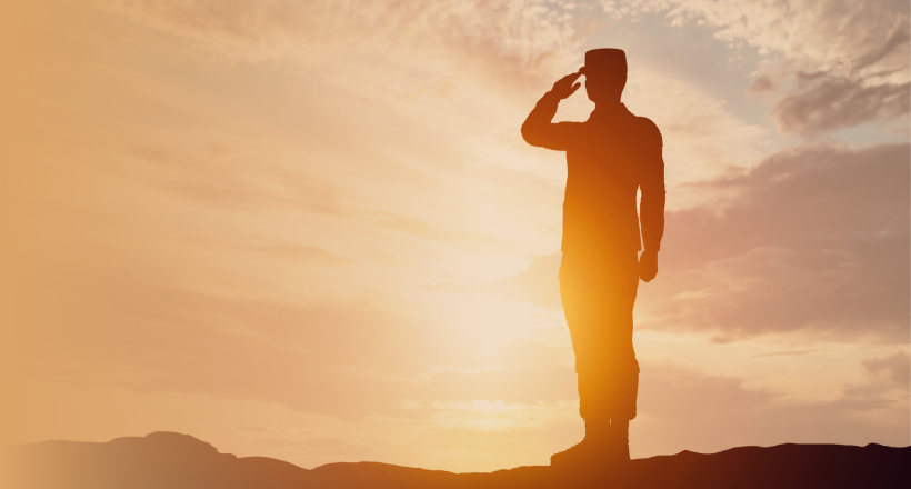 A silhouette of a military service member saluting.