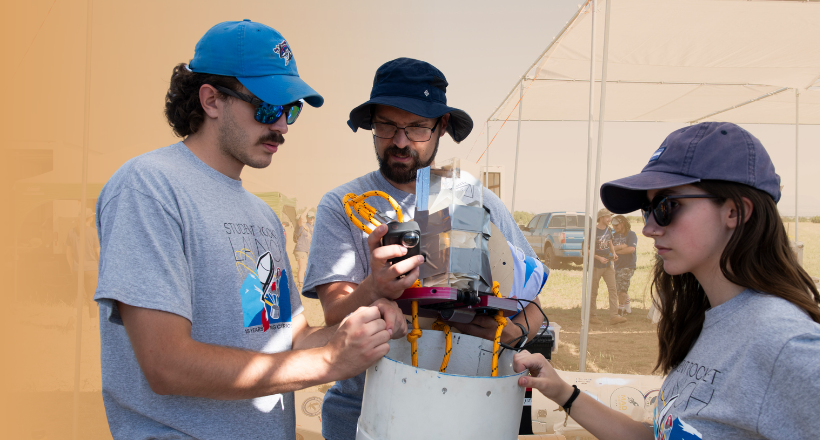 A mentor working with two mentees outside during BIRST.