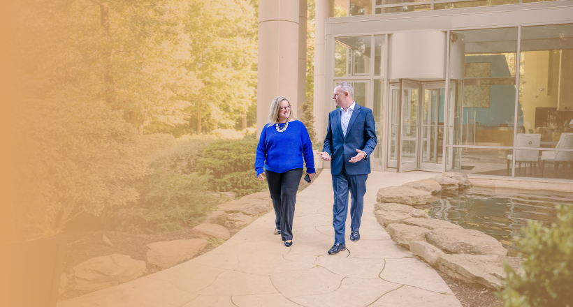 Two employees walk in the courtyard of a BAE Systems building.