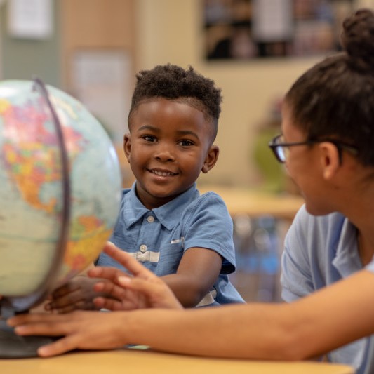 boy and teacher with globe