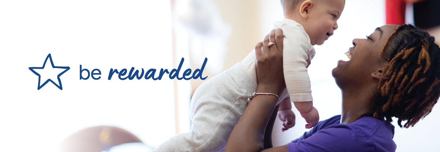 A joyful caregiver lifts a smiling baby in the air, with the text "be rewarded" and a star icon on the left.