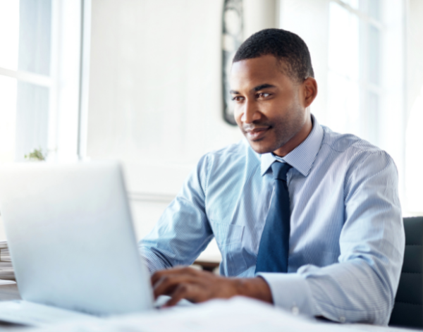 Individual sitting and focused on laptop