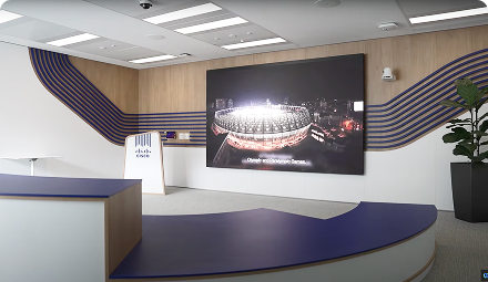 A modern reception area in our Paris office with an image of the Olympic and Paralympic stadium on the wall.