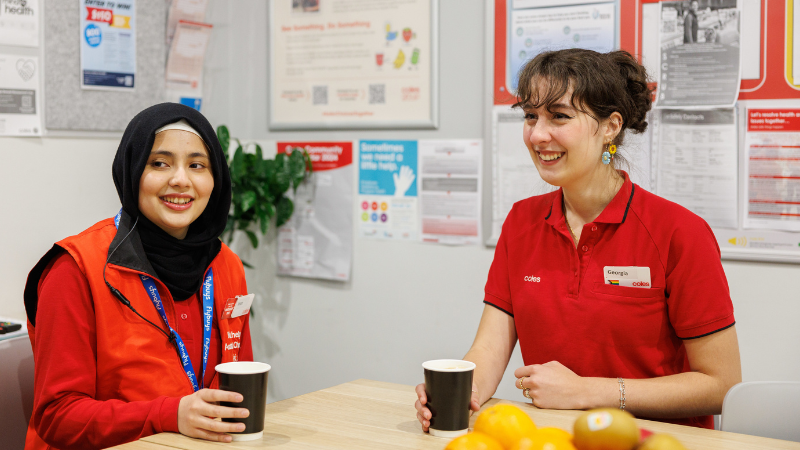 Two Coles team members sitting together in a staff room during a workplace break