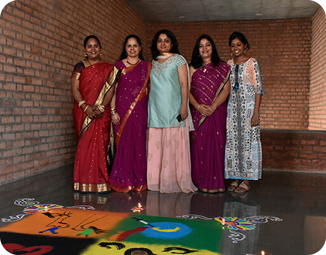 Team celebrating with traditional rangoli artwork