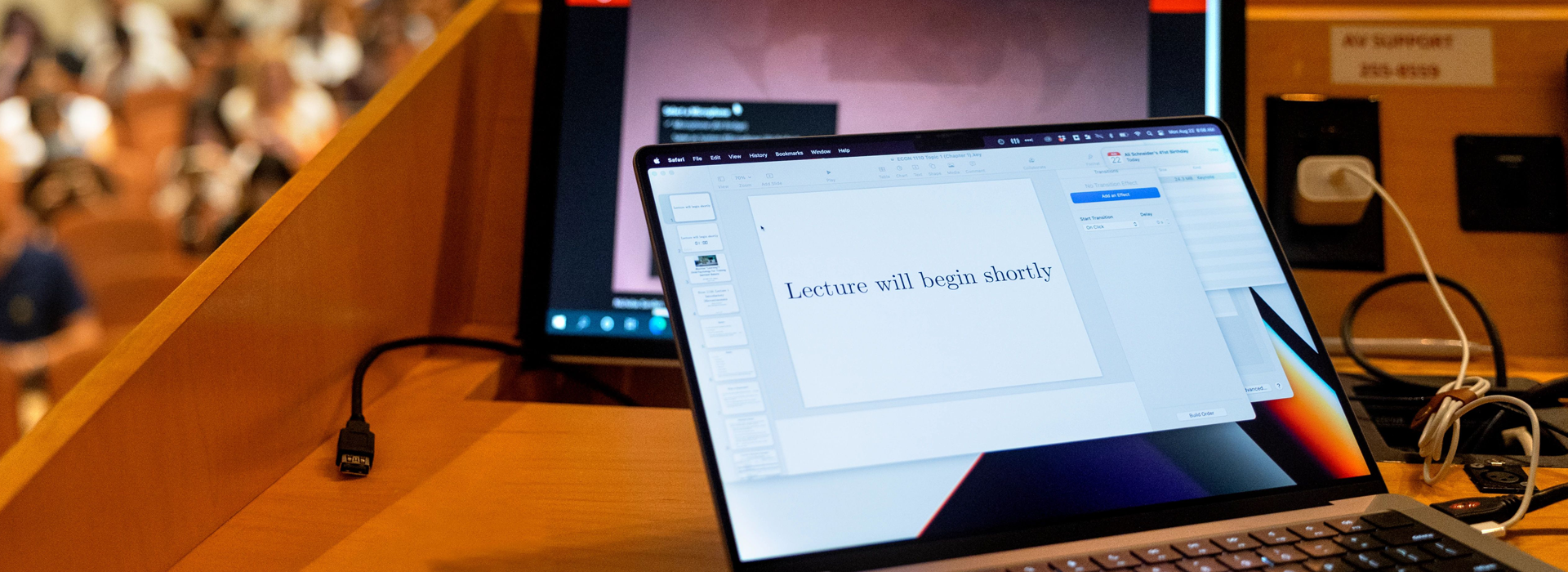 laptop on podium in lecture hall "lecture will begin soon"