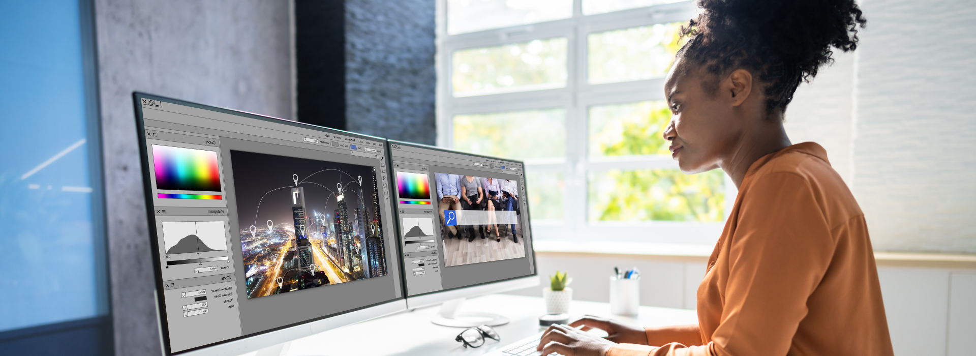 Black woman working with two computer monitors video editing