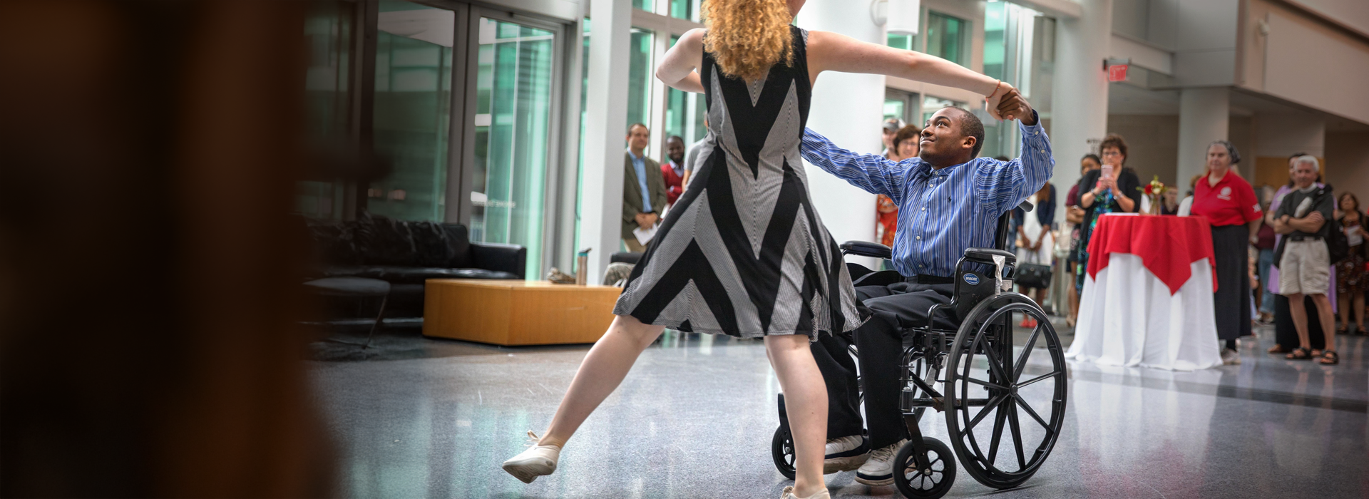 Black man in wheelchair dancing with woman at a performance at Cornell
