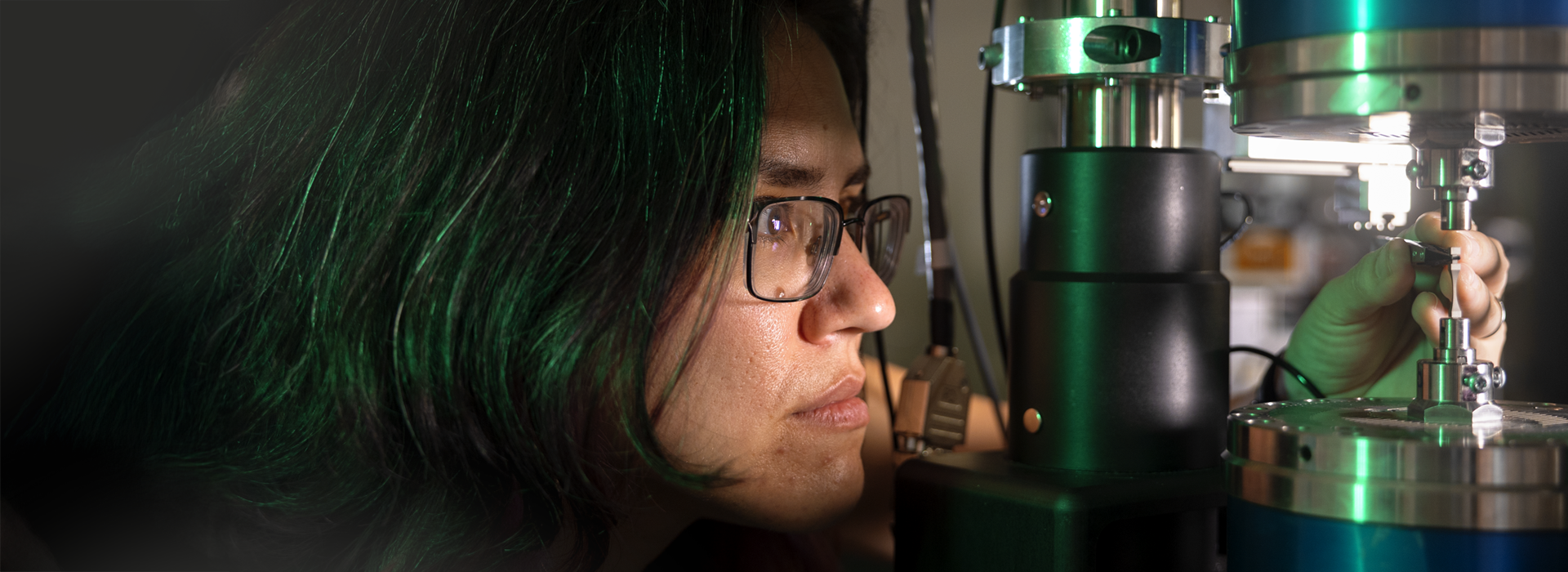 woman concentrating on lab machinery