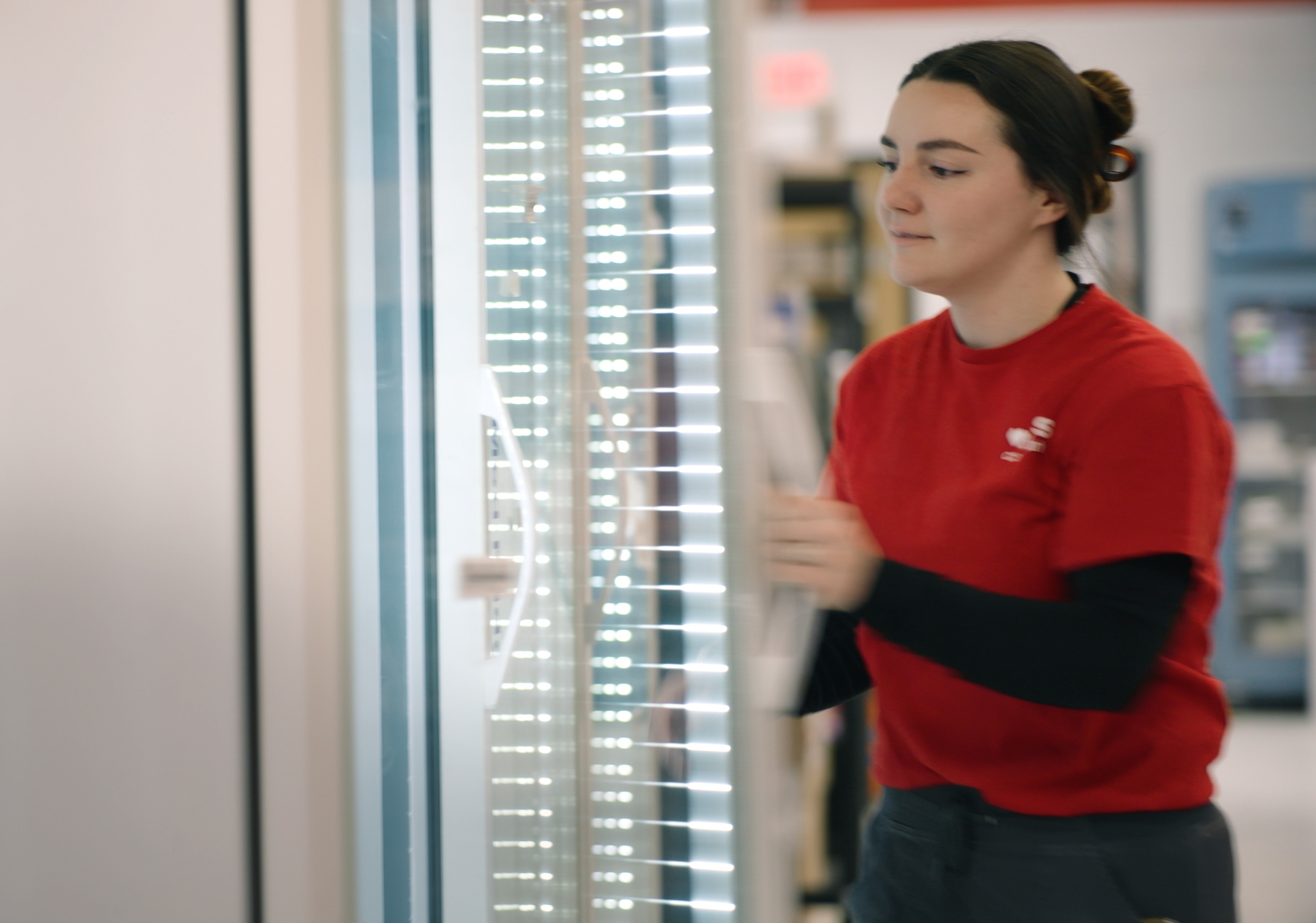 Woman pharmacy technician opening the fridge