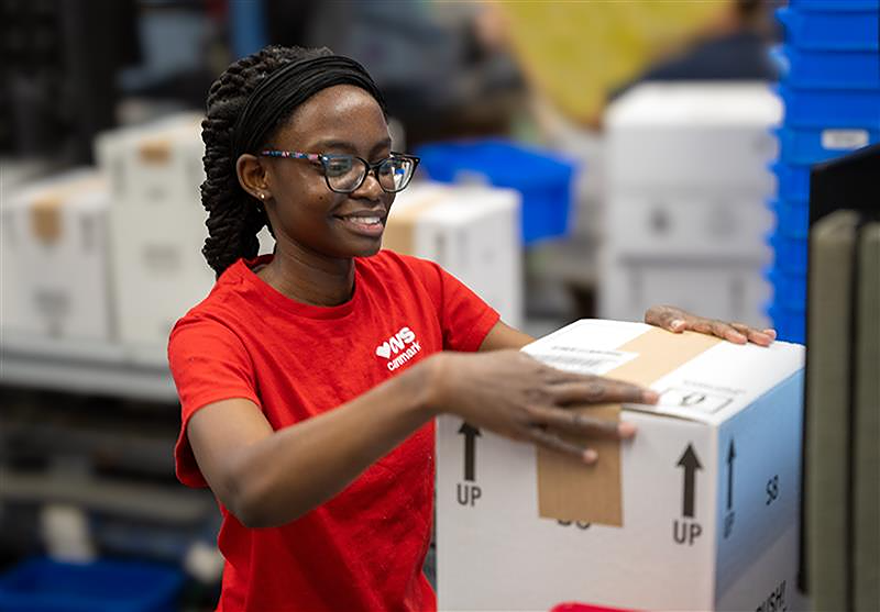 Woman pharmacy technician packaging up a box
