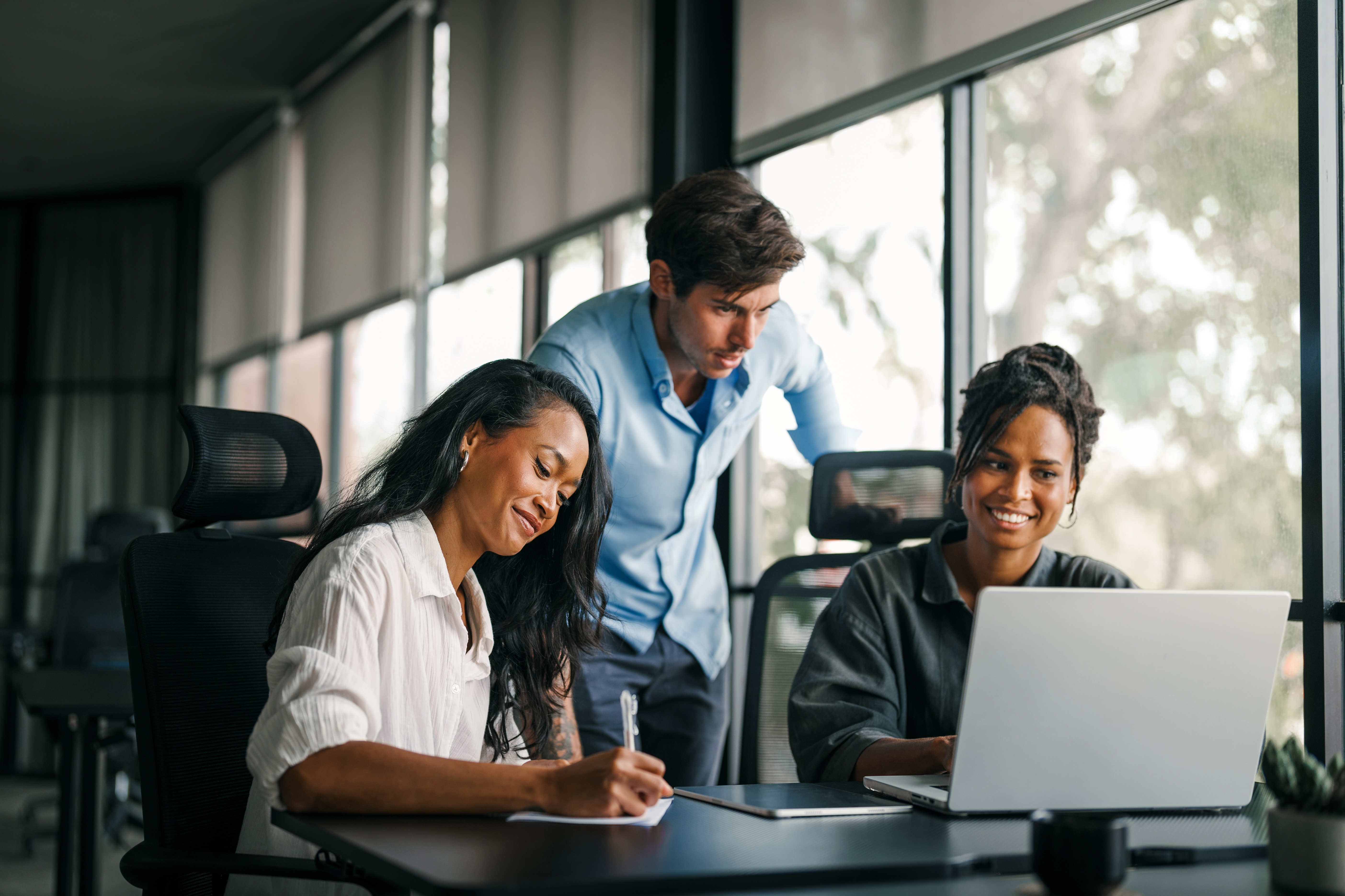Three diverse colleagues collaborate in a modern office.