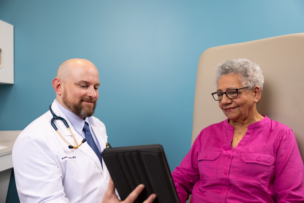 Doctor holding tablet talking to patient