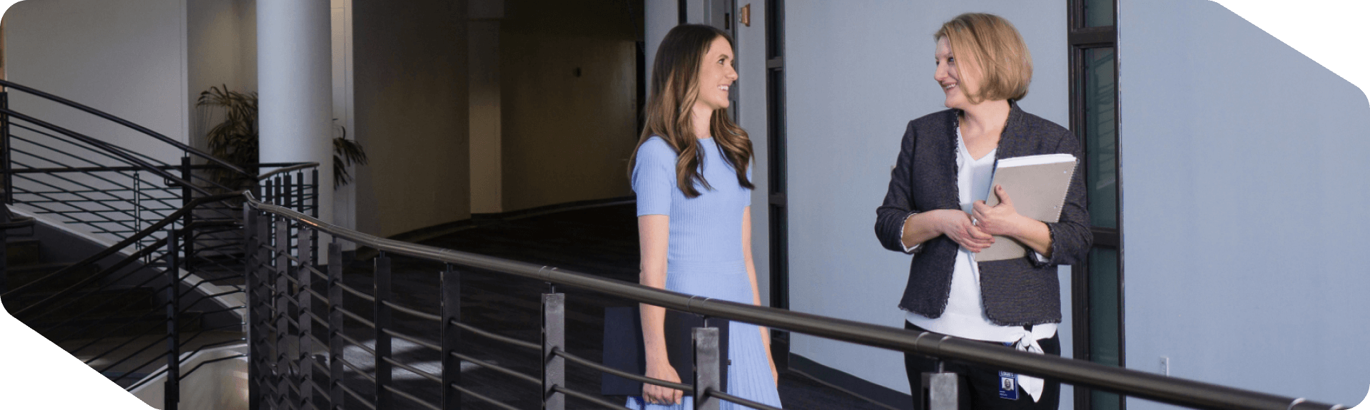 Two Lowe's corporate associates walking and discussing work at corporate headquarters