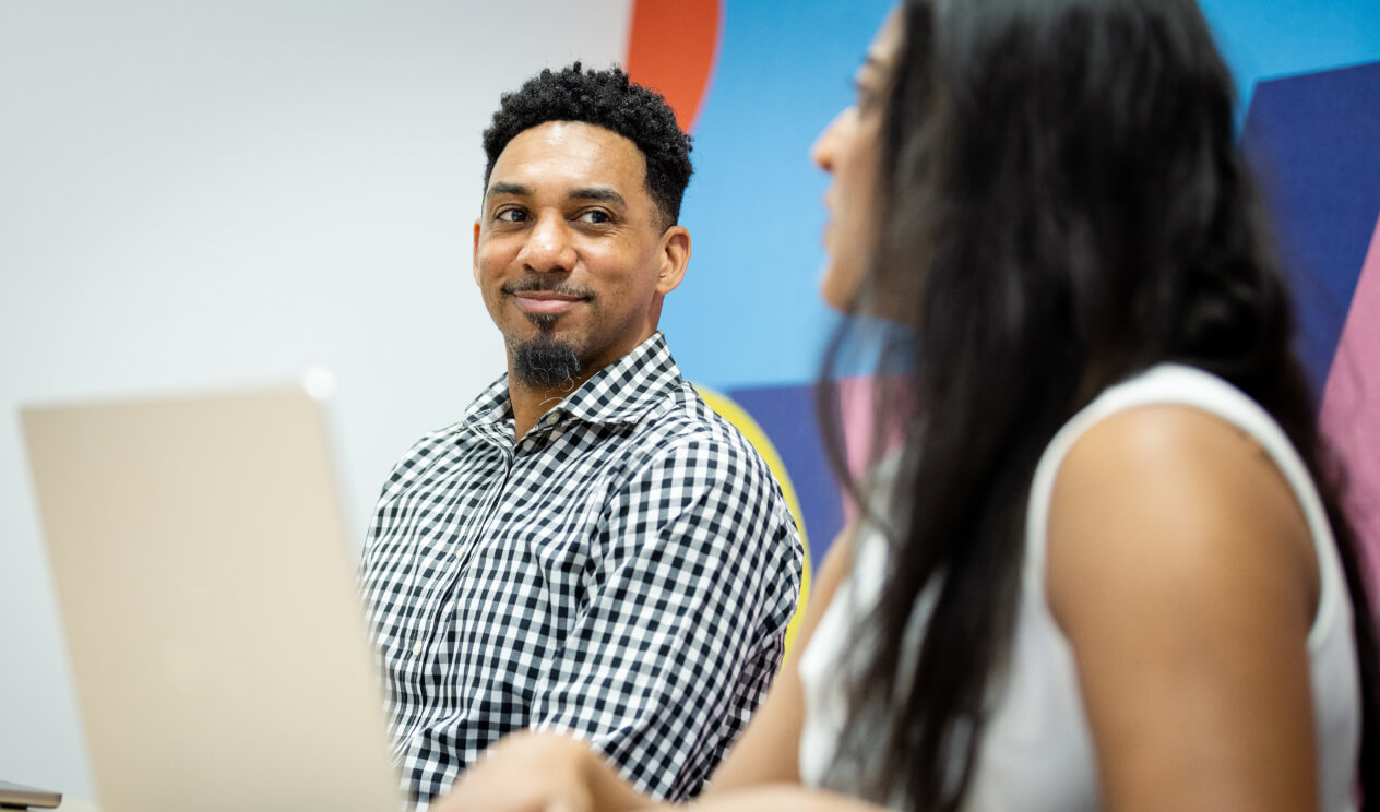 Associates smiling and talking during a meeting