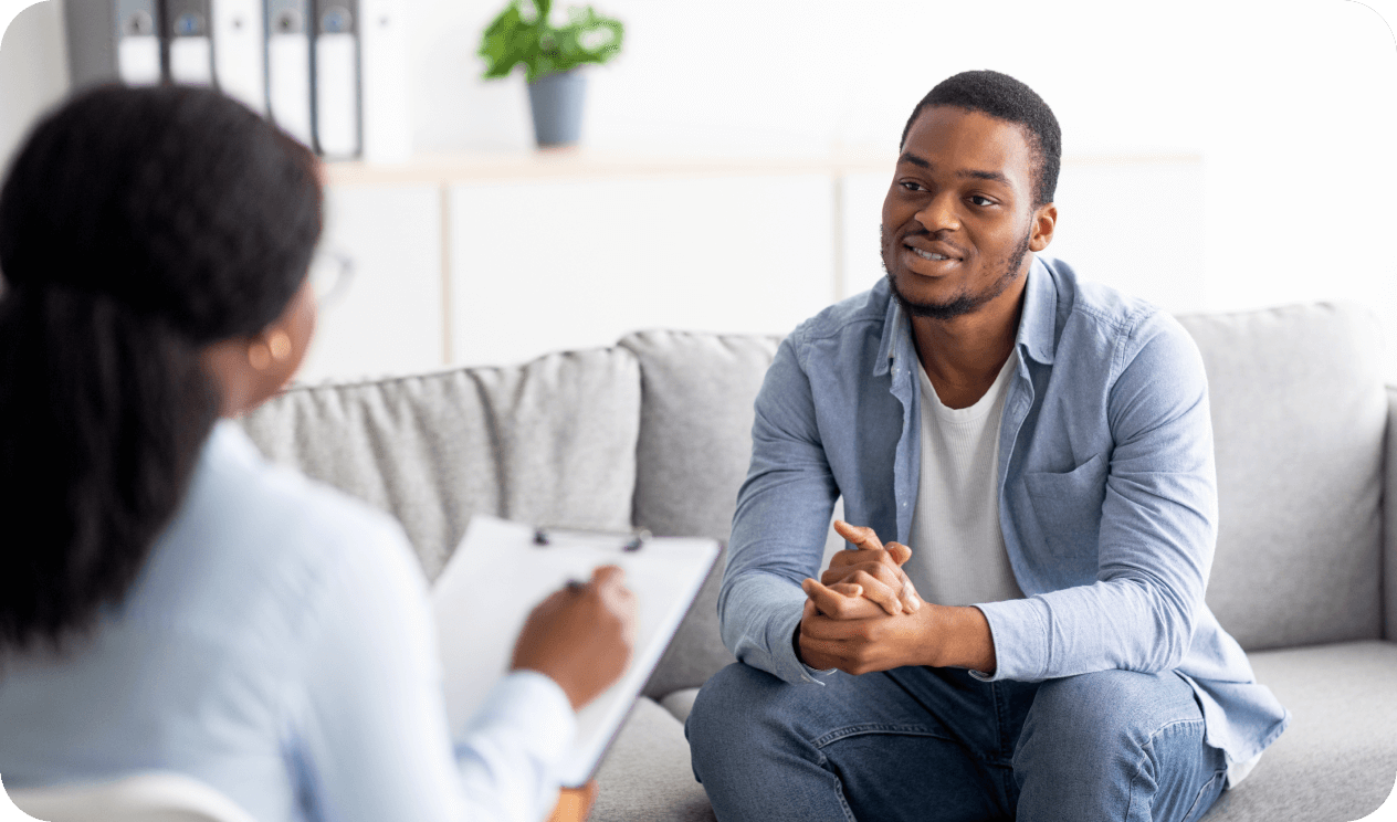 Young man on a couch having a conversation with a health care provider
