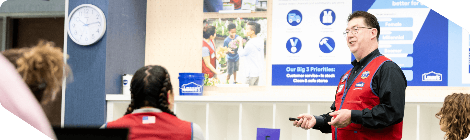 Lowe’s associates in red vests attend a training session.