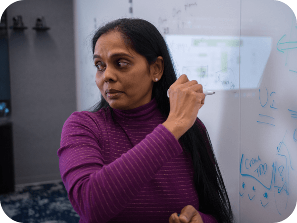 Lowe's Tech associate writing on a whiteboard during a meeting