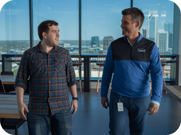Two Lowe's associates talking and walking through the Tech Hub