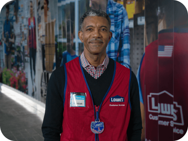 Lowe's associate standing in front of a mural at Corporate headquarters