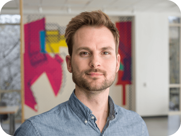 Male associate standing in an open workspace at Corporate Headquarters