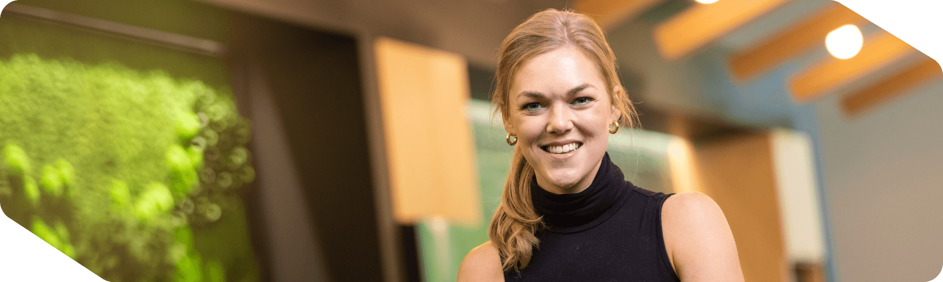 Corporate Lowe's associate smiling confidently in an open workspace at headquarters