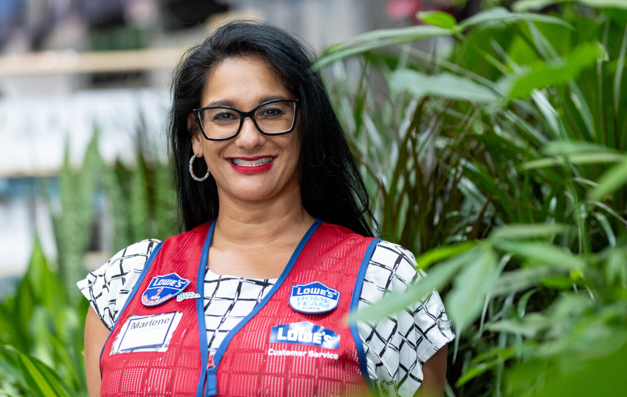 Female associate wearing a red vest working in the Garden Center