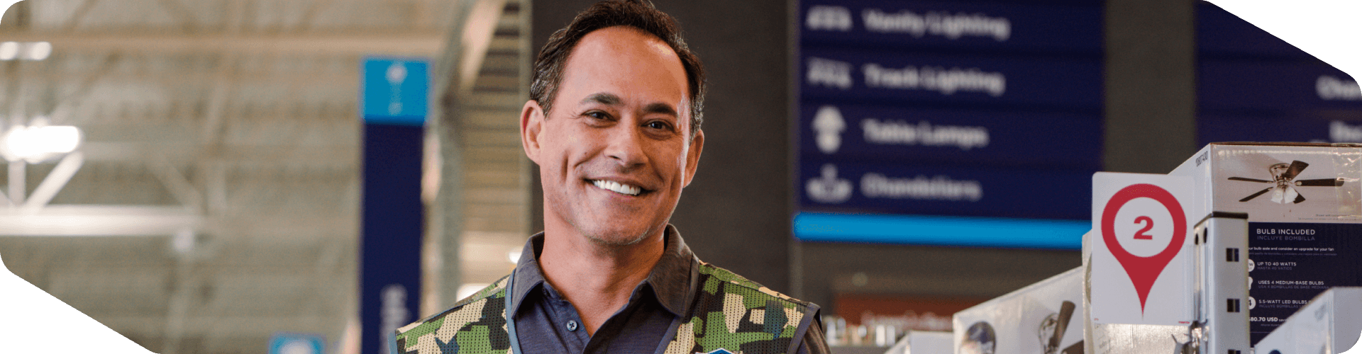 Lowe's associate stocking fans while wearing a military vest