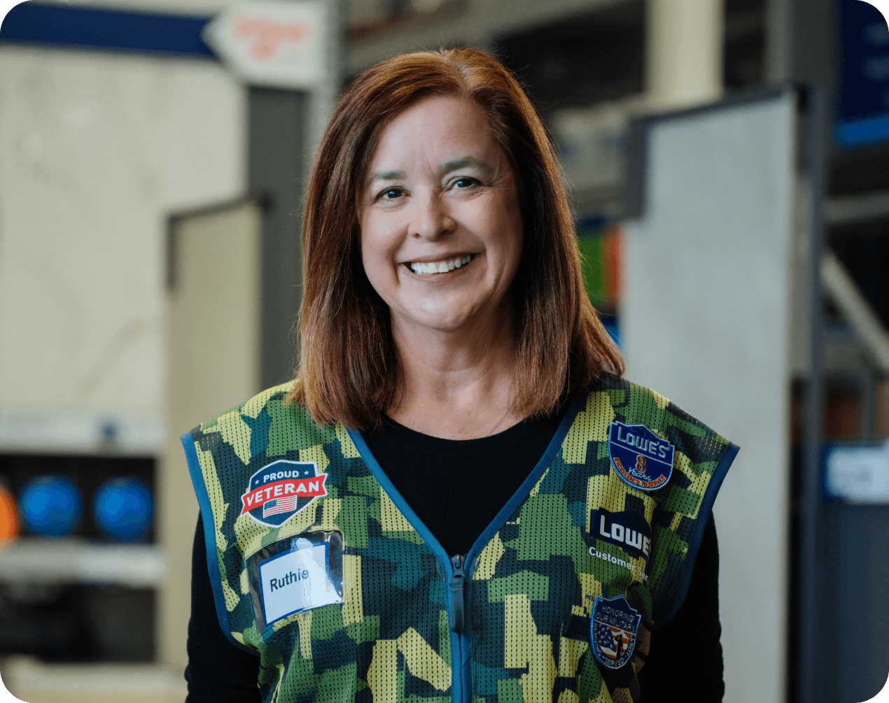Lowe's associate wearing a military vest and enjoying her job