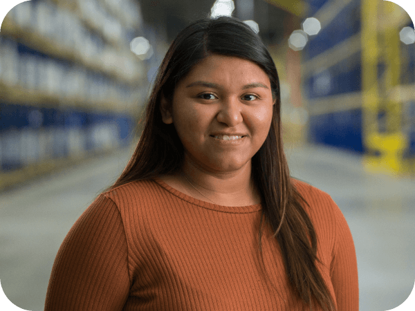 Supply Chain associate standing confidently in a warehouse